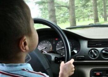 Un copil de 9 ani, filmat conducând un vehicul în brațele tatălui său!