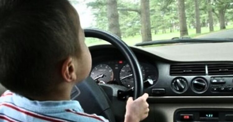 Un copil de 9 ani, filmat conducând un vehicul în brațele tatălui său!